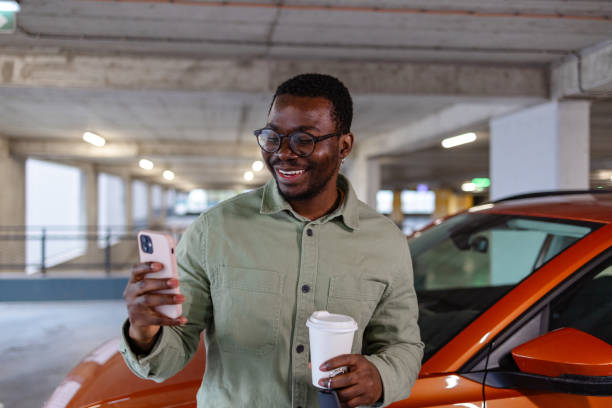 A young modern man paying for car parking with a mobile app on his cell phone A young modern man paying for car parking with a mobile app on his cell phone